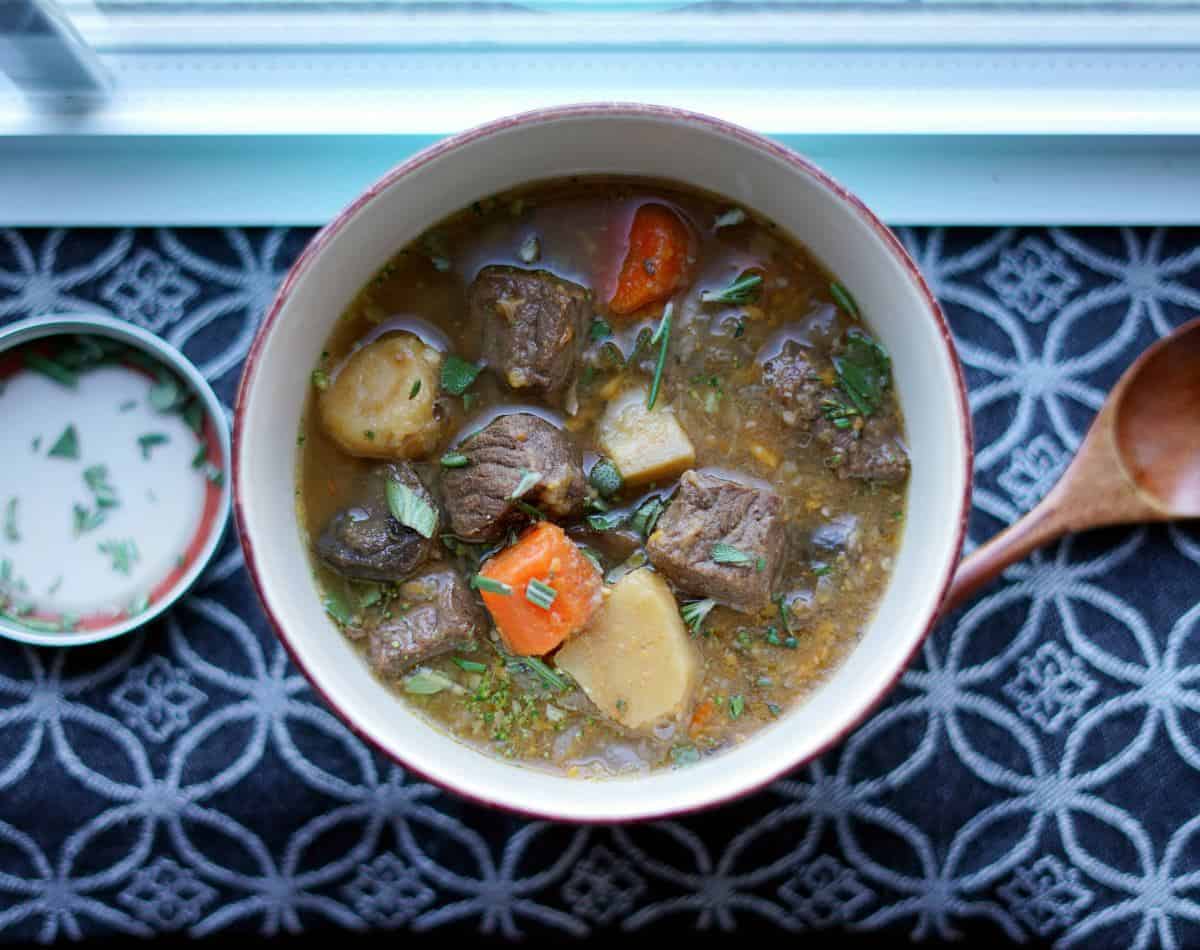 Overhead view of aip beef stew next to a window.