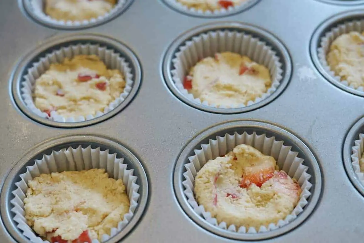 unbaked strawberry rhubarb muffins in a baking tin.