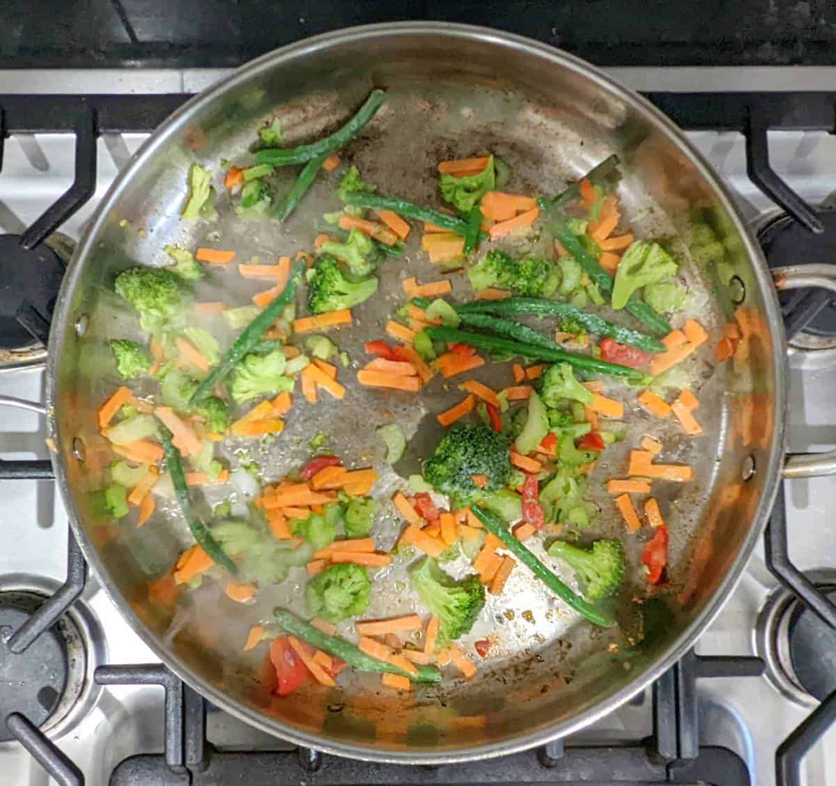 Stir fry vegetables in a pan cooking.