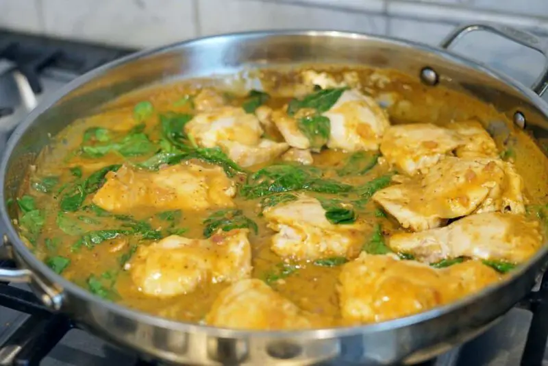 strawberry basil chicken cooking in a large metal pan on the stove