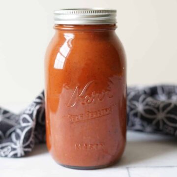 Nomato sauce in a mason jar with a black towel behind it.