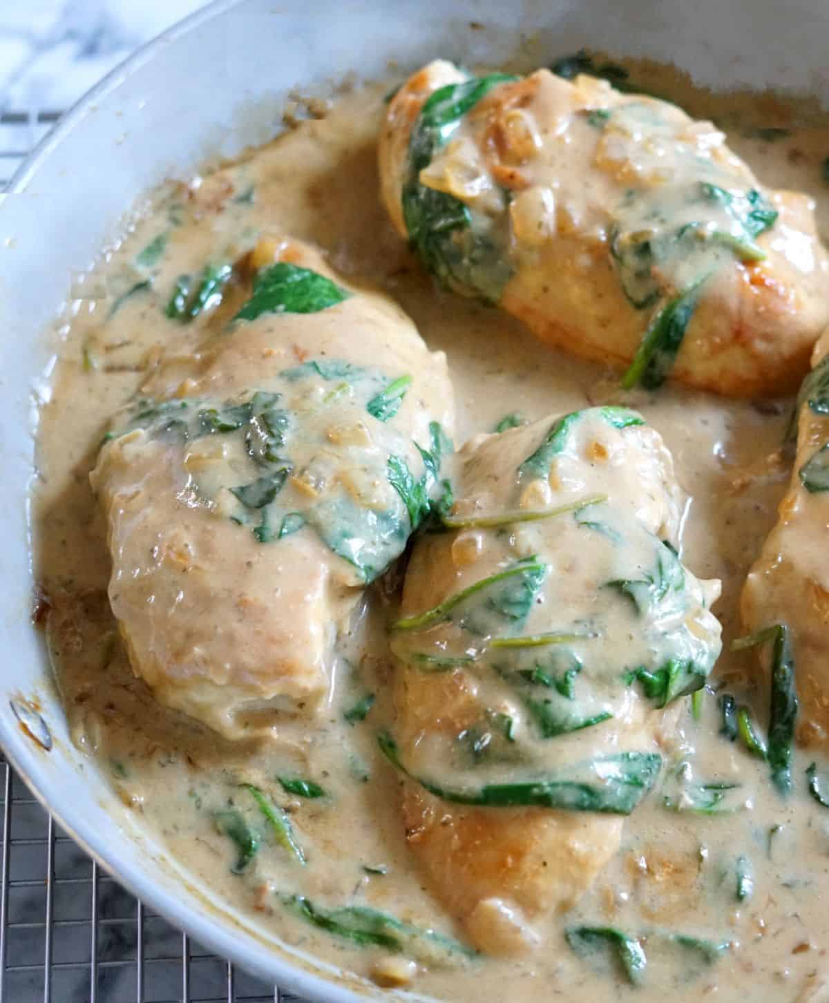 aip chicken florentine in a tan pan on a white marble counter