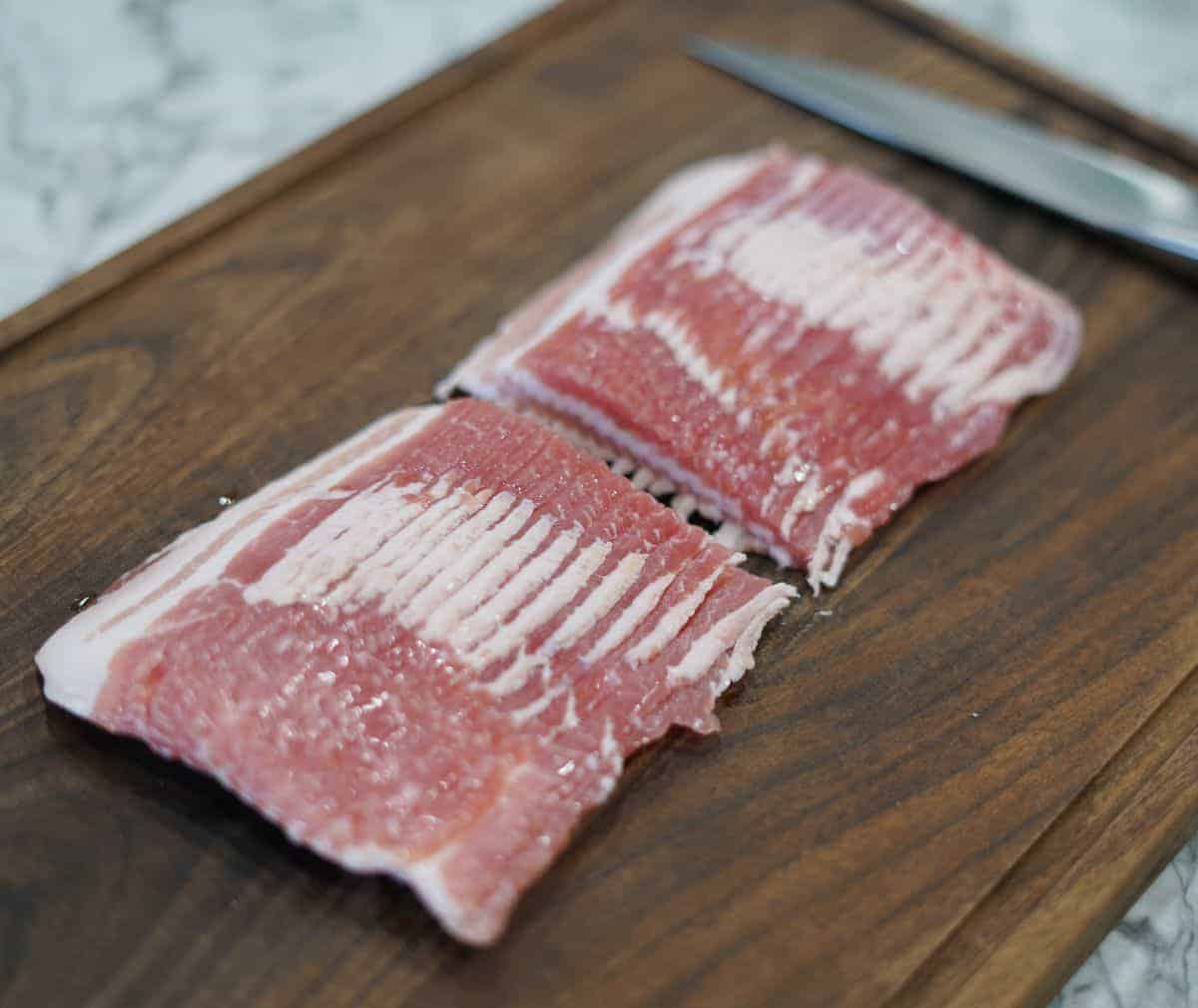 stack of raw bacon right out of the package and cut in half