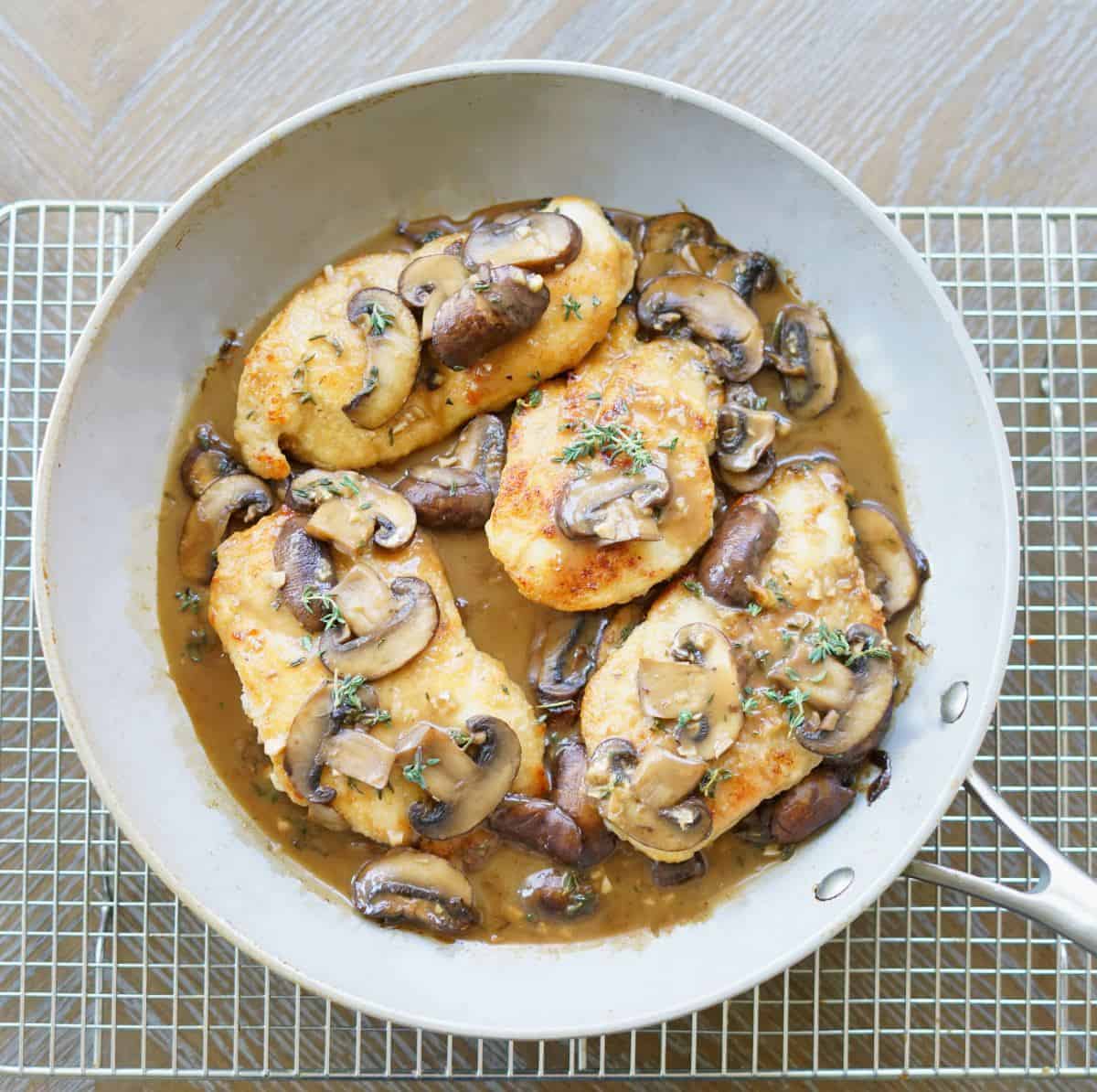 Paleo Chicken Marsala in a gray pan on a cooling wrack.