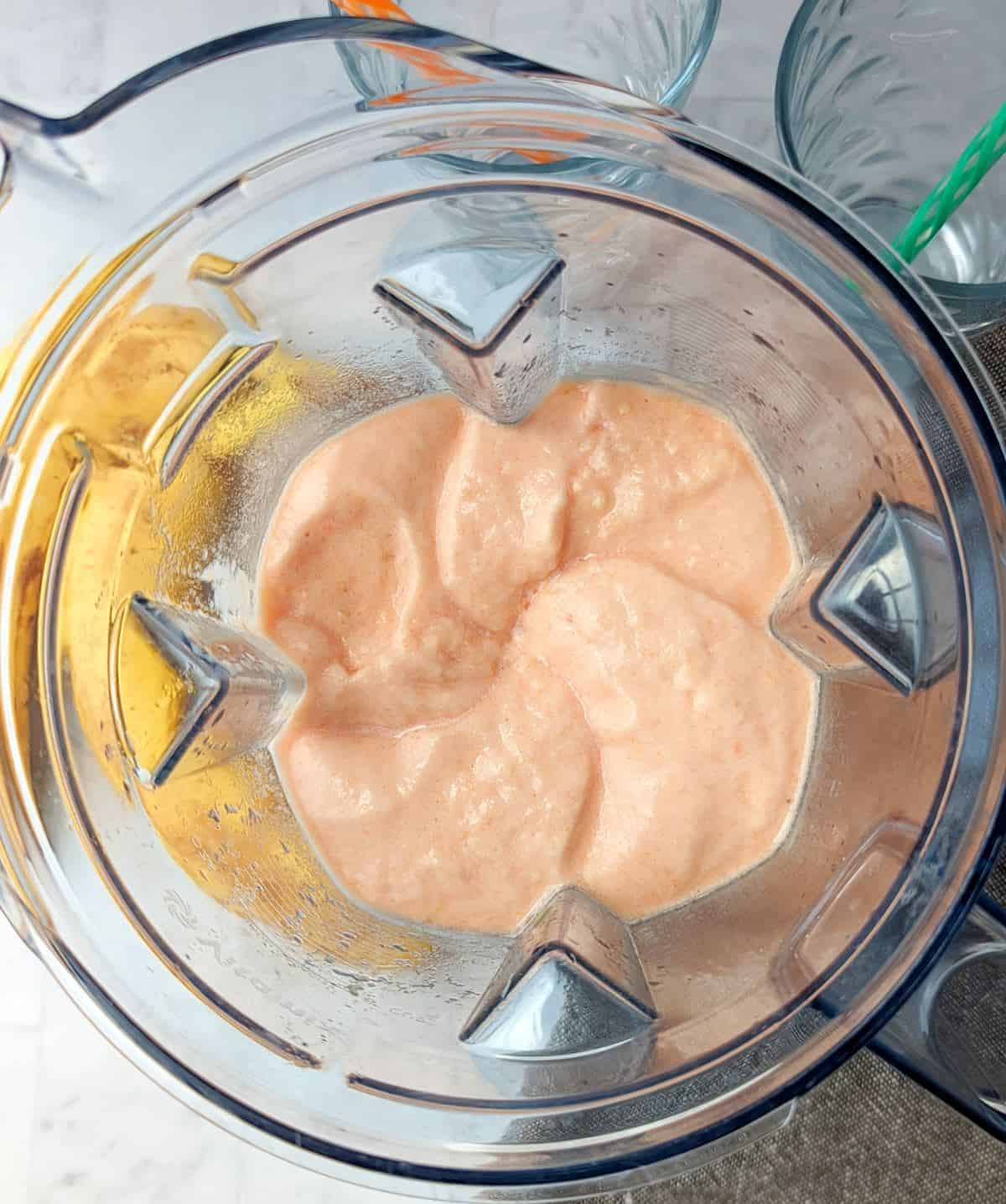 Overhead view of watermelon smoothie in a blender.
